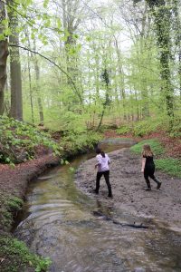 two kids run wild in a creek 